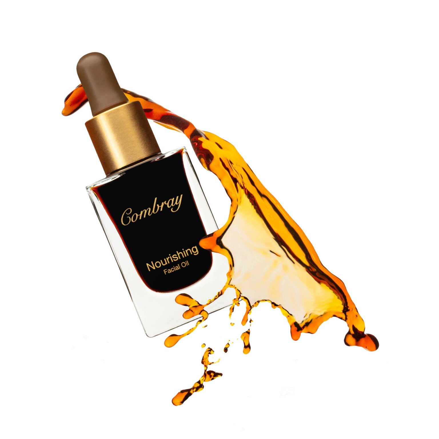 Dit beeld toont een elegant ontworpen flesje Combray Nourishing Facial Oil. De fles lijkt te zweven tegen een witte achtergrond, terwijl een dynamische, amberkleurige olie er soepel omheen vloeit. De elegante gouden dop en het bijpassende etiket geven een gevoel van luxe. Fotograaf: Jan Buwalda, Groningen.