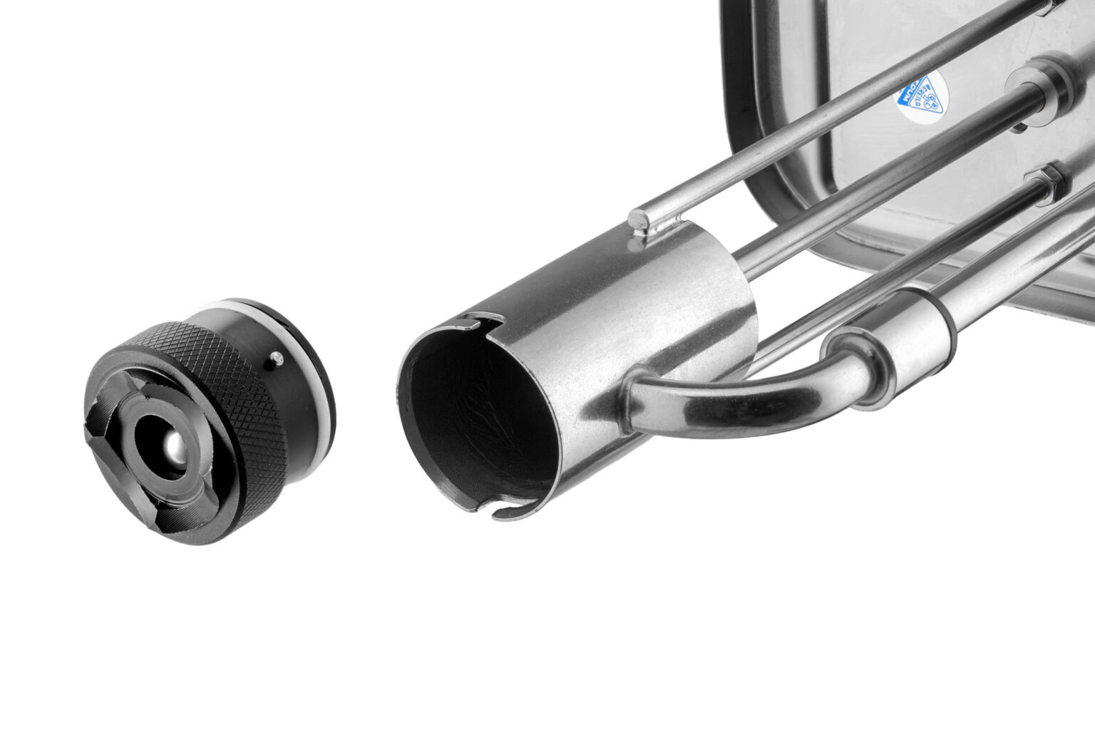 Ik kan je geen informatie geven over de fotograaf, maar ik kan wel de afbeelding beschrijven.Deze afbeelding toont een close-up van een metalen mechanisch onderdeel. Aan de linkerkant is een zwart, cilindervormig object te zien met een geribbeld oppervlak voor grip en een centrale opening. Rechts hiervan bevindt zich een glanzend metalen onderdeel met een gebogen pijpstructuur, dat lijkt te passen in het zwarte onderdeel. Dit zijn waarschijnlijk onderdelen van een technische of industriële toepassing. De witte achtergrond zorgt voor een helder contrast en benadrukt de details van de objecten.